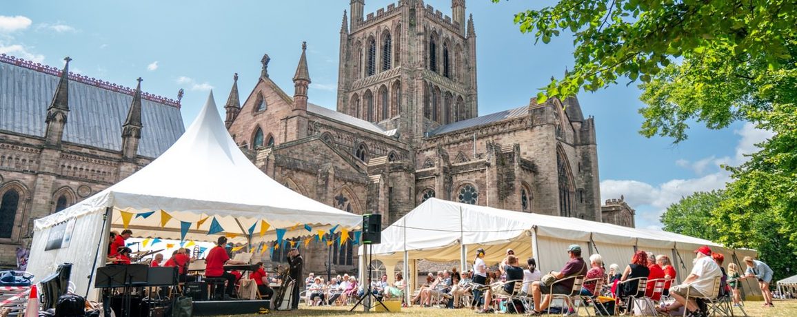 A view of marquees in front of Hereford Cathedral, sunny.
