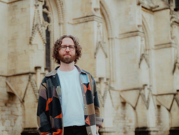 Gavin Higgins standing in front of Gloucester Cathedral